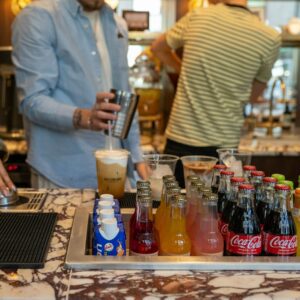 a group of people standing around a bar with drinks